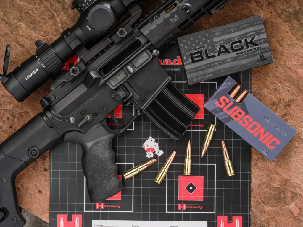 An AR-15 rifle beside boxes and loose cartridges of .338 ARC subsonic ammo