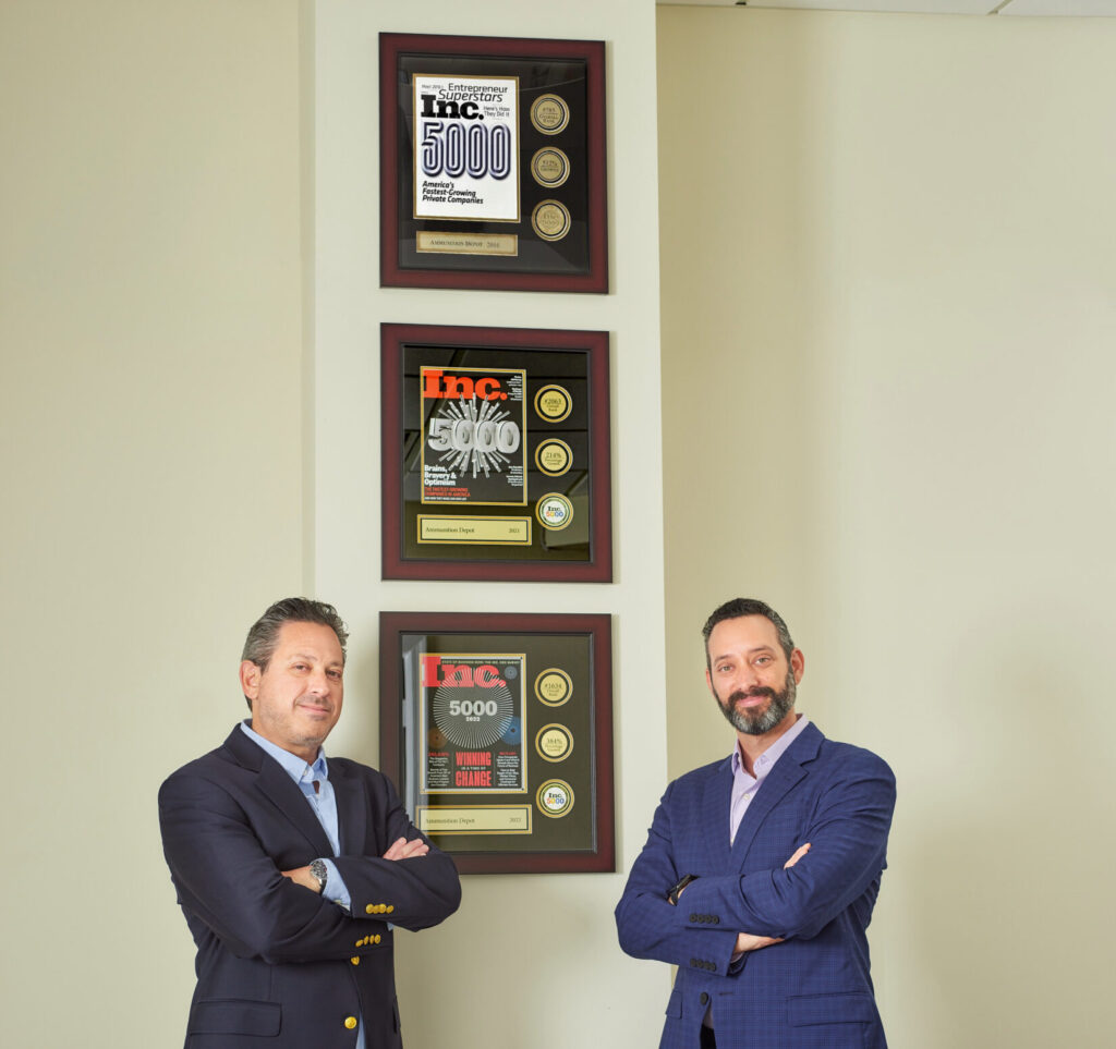 two businessmen in front of awards