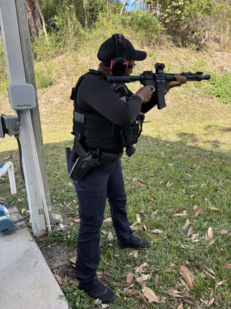 female law enforcement officer aims rifle downrange