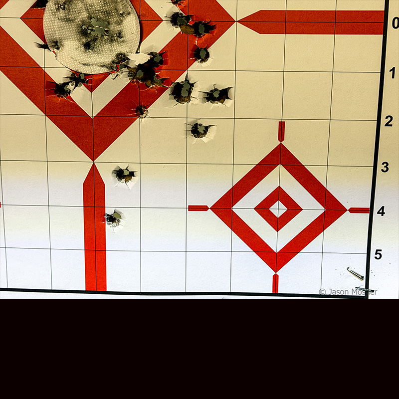 A target with bullet holes all over it from shooting a gun using a thermal optic. 