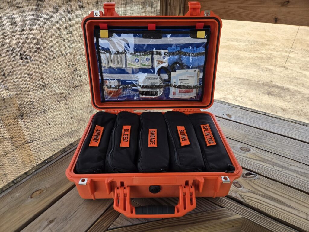 A large medical kit with organized components against a wooden backdrop