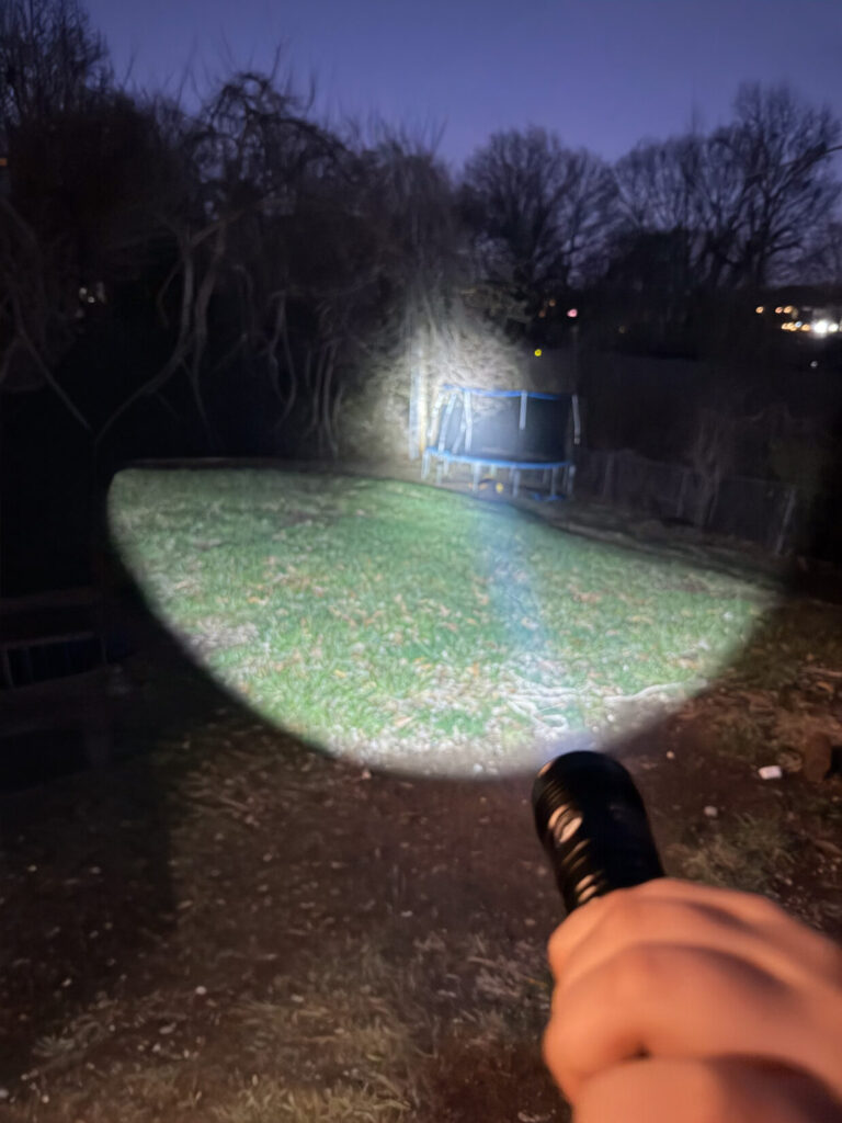 a bright flashlight with a nighttime backdrop