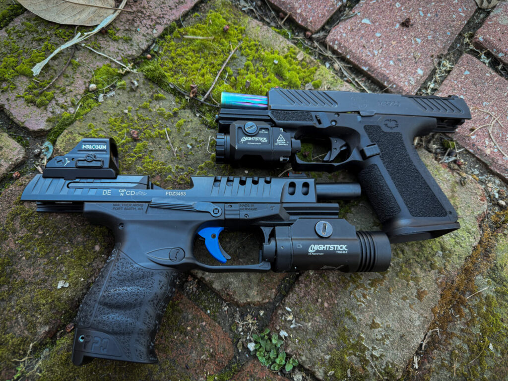 two black handguns with flashlights