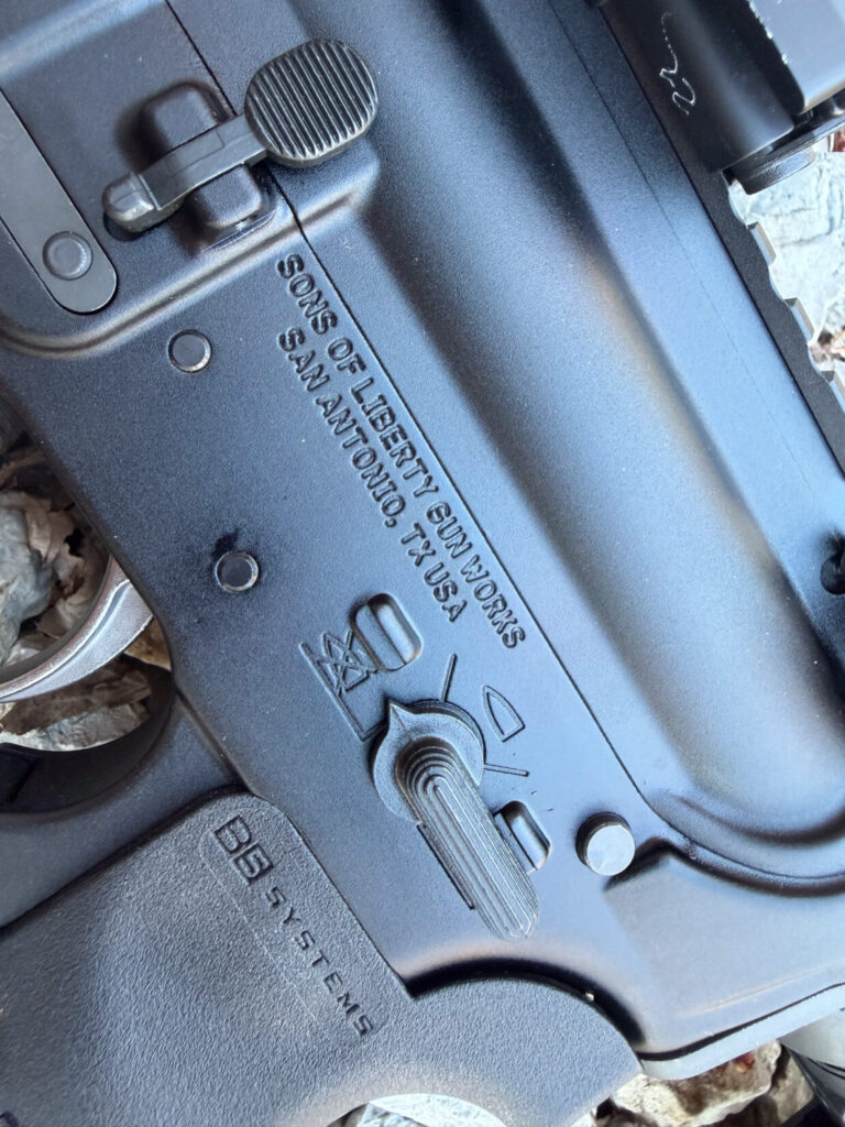 Black AR-15 receiver with engraved text