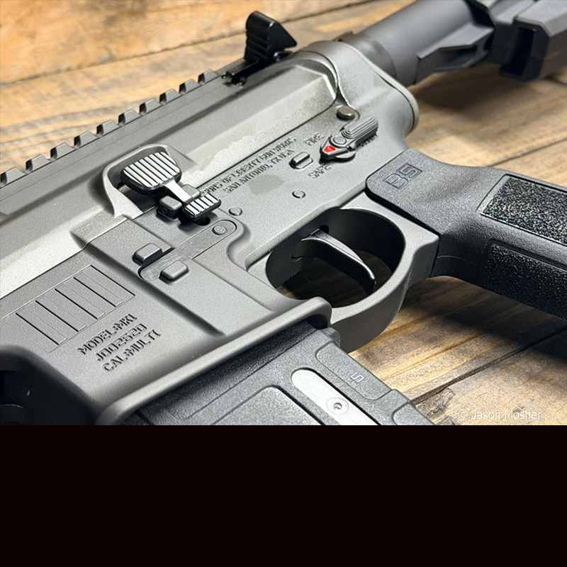 A side view of the MK1 rifle, showing the magazine well, trigger, and upper receiver. 