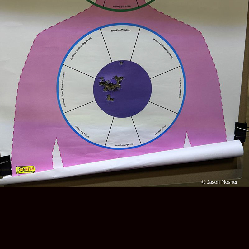 A pink target with a white and blue circle in the middle. Several holes are in the center from the test fire of the MK1. 