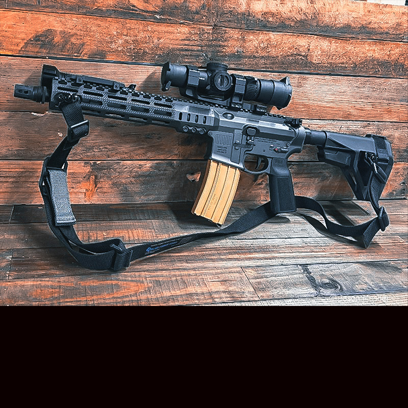 An AR 15 from Sons of Liberty Gunworks, leaning up against a wooden wall. 