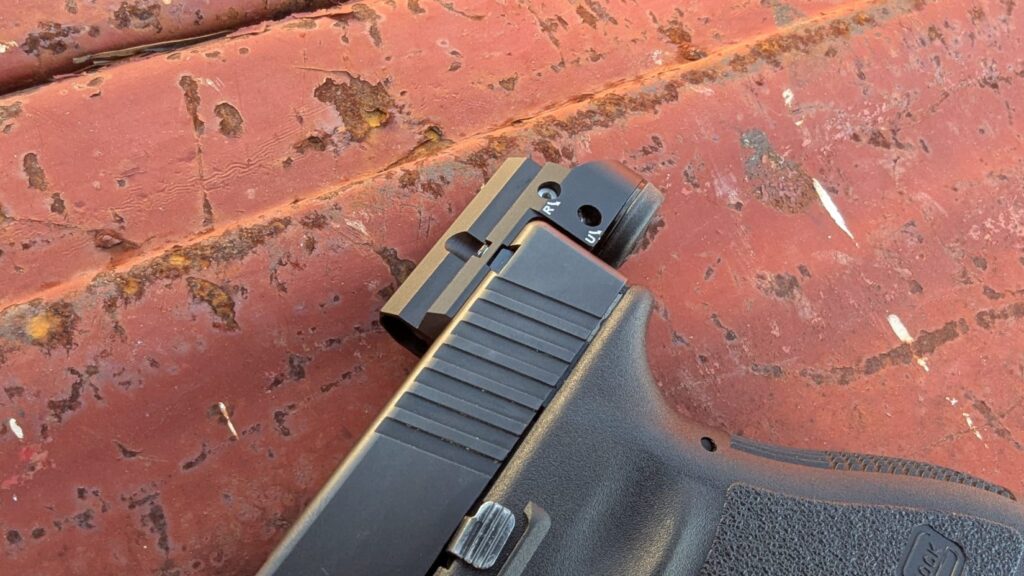 A close-up, side profile of a Glock slide showing the Leupold DeltaPoint Micro’s unique mounting position, which sits behind the slide and replaces the rear sight.