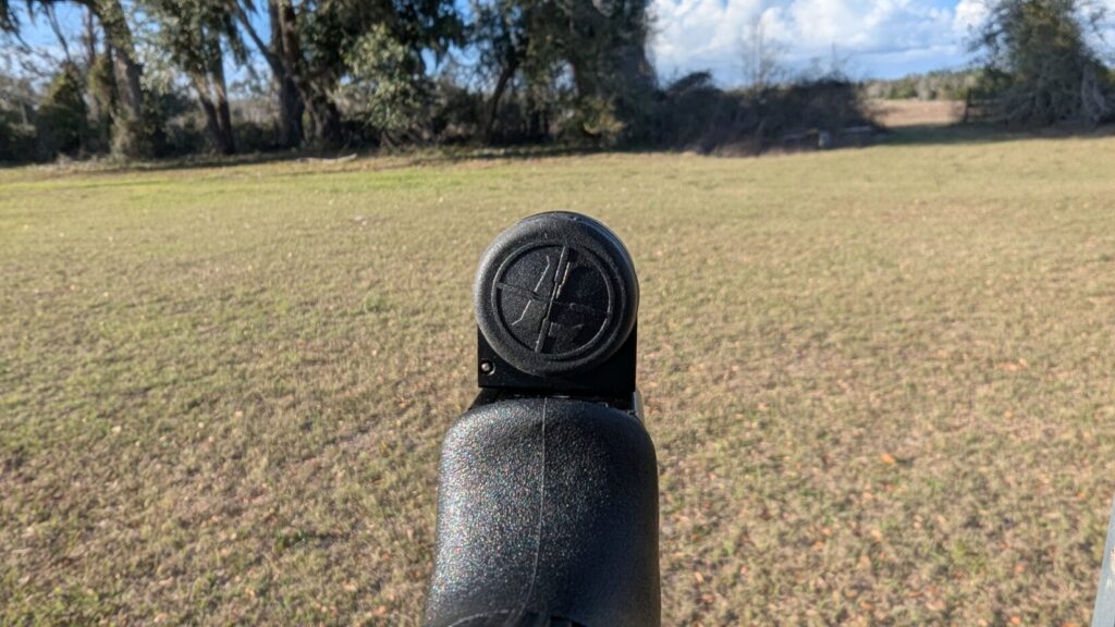 A first-person view looking down the slide of a Glock at the rear-mounted Leupold DeltaPoint Micro with its protective rubber cover on.