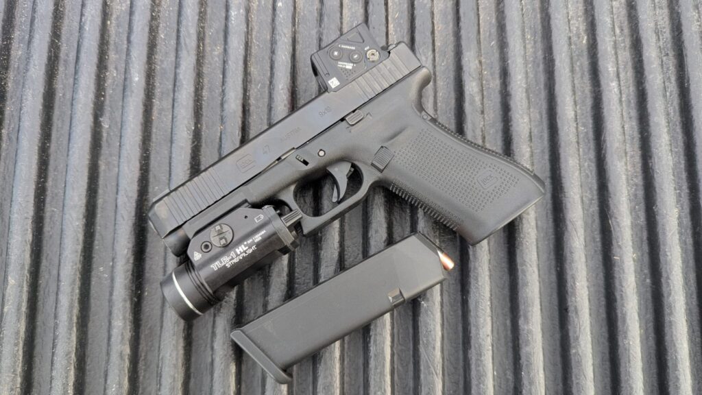 Full left-side profile of the Glock 47 Gen 5 setup with the Aimpoint COA and Streamlight TLR-1 HL against an outdoor backdrop.