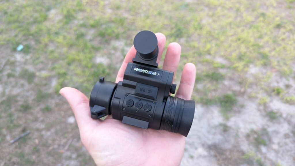 Side view of the NVG 50 in hand, highlighting the "Goodnite Gear" logo, control buttons (Power, IR, Menu), and USB/SD card port covers.