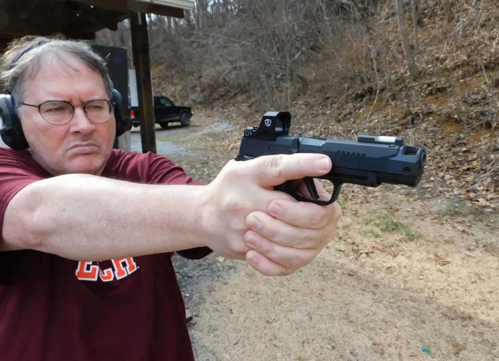 Man shooting a pistol equipped with a Riton Optics 3 Tactix MPRD XL pistol optic