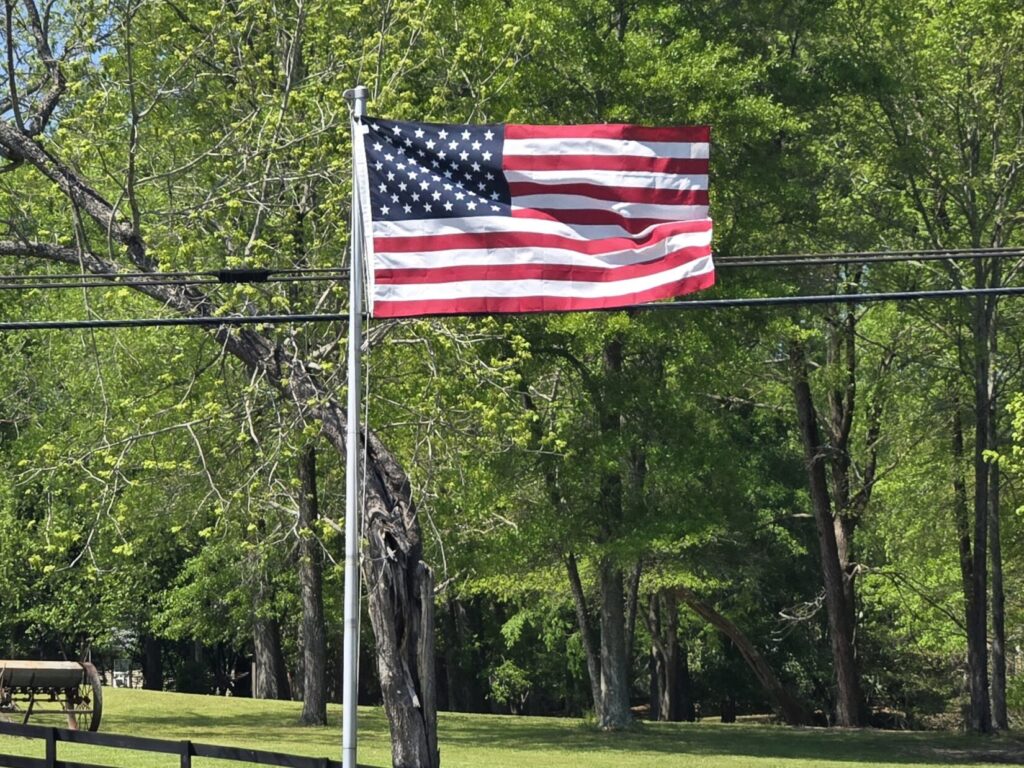 An American flag on a flag pole blowing in the wind