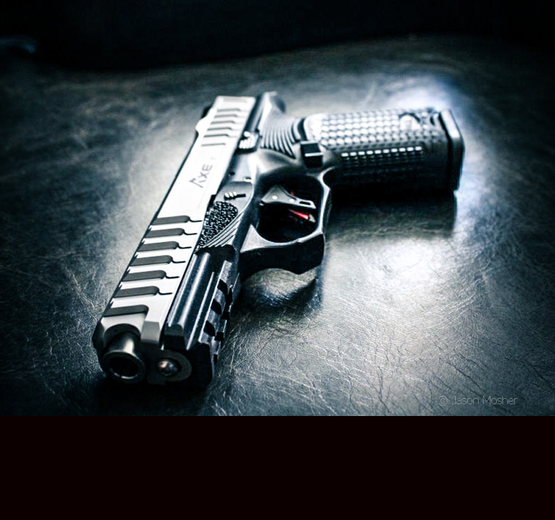 A black and silver handgun on a dark surface. 