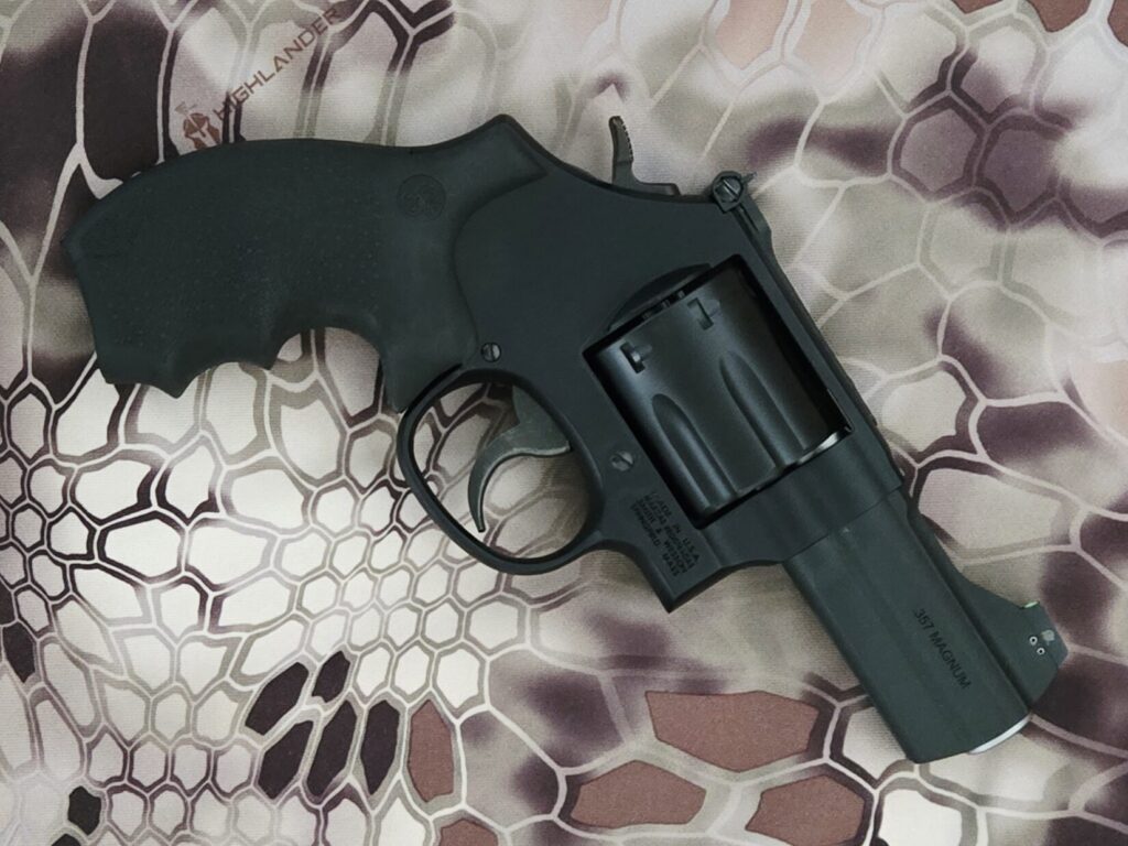 a black revolver on a kryptek highlander background