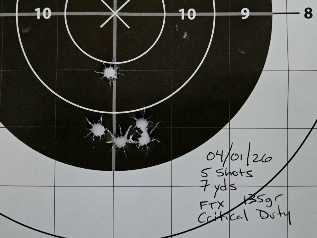 A bullseye target with 5 bullet holes in it.