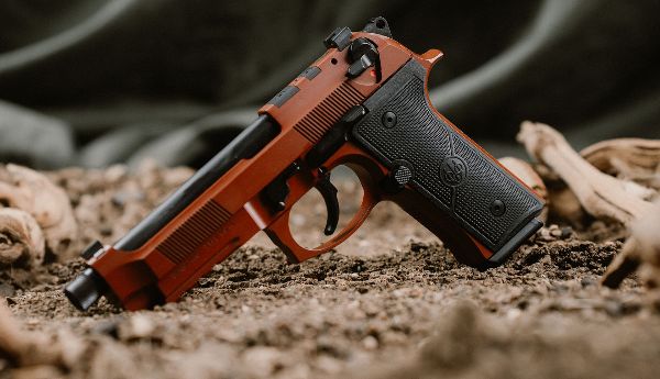 A pistol on a dirt background.