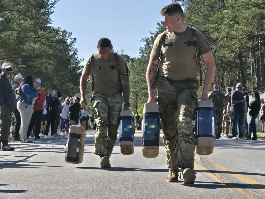Soldiers carry water jugs on a road