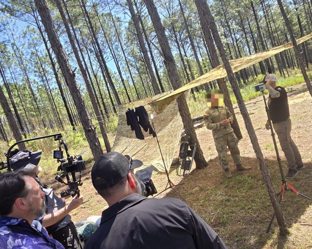 A camera crew films a man and a soldier