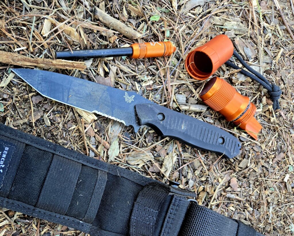 A knife and fire starter along with an orange container and sheath