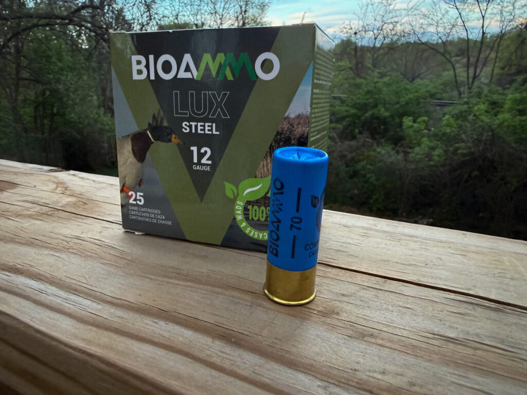a box of shotgun ammunition on a wood surface with a green background