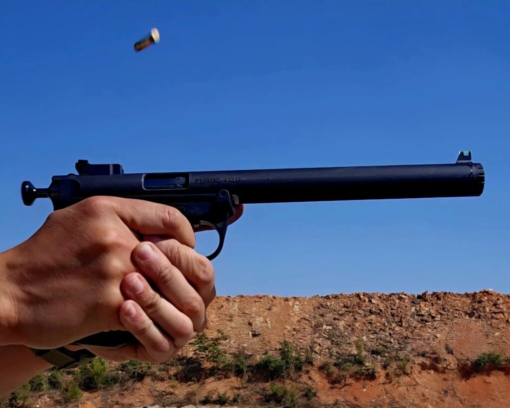 A pistol and a spent casing mid air