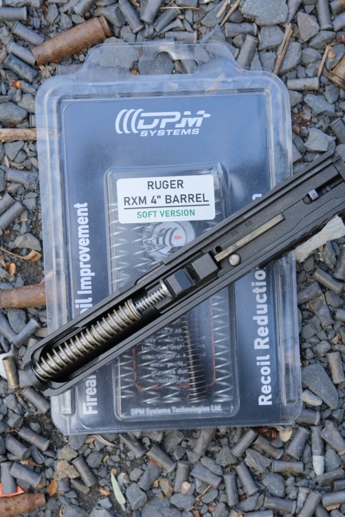 Top down view of the DPM System guide rod installed in the RXM slide, sitting on top of DPM factory packaging with extra springs