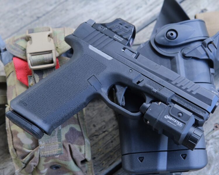 Ruger RXM in a full size black grip frame with holosun SCS320- and Nightstick TCM-10-T on top of a Safariland Ballast Duty holster