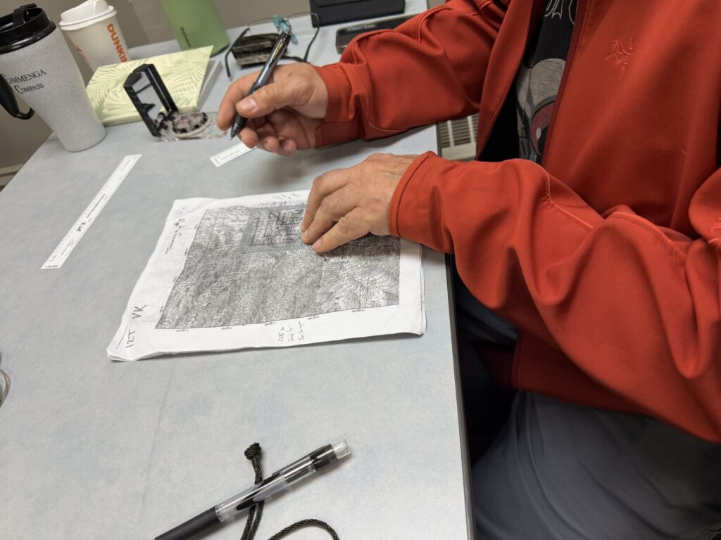 A student using a map and protractor in the classroom portion of a Kevin Estela land navigation class.