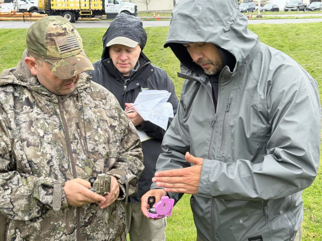 Kevin Estela using his signature pink compass while working with students during a field land navigation exercise