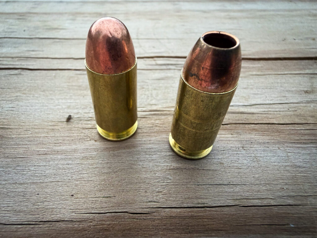 two handgun cartridges side-by-side on a wood surface