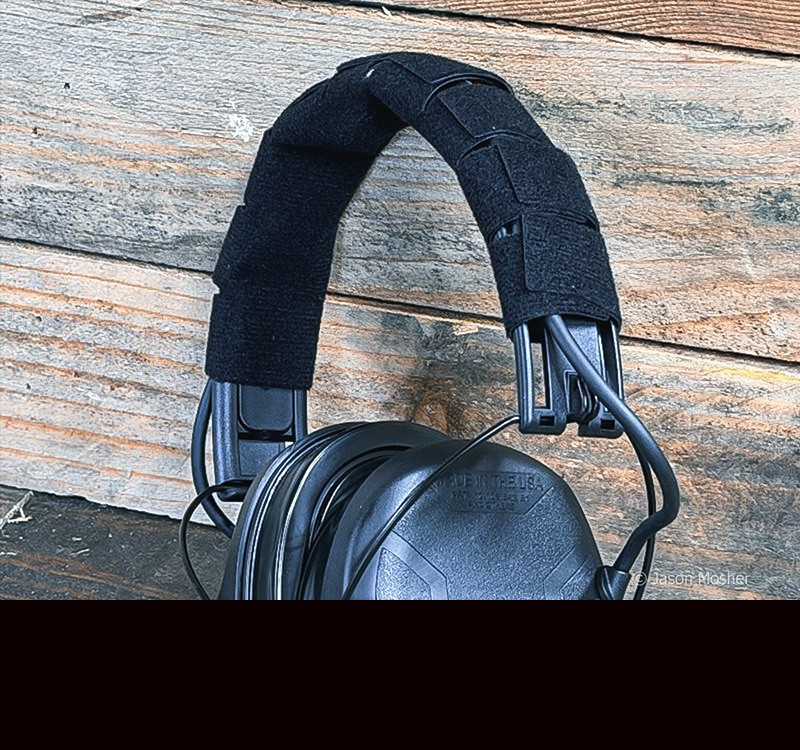 The soft, black headband on the Safariland headset, leaning up against a wood table.
