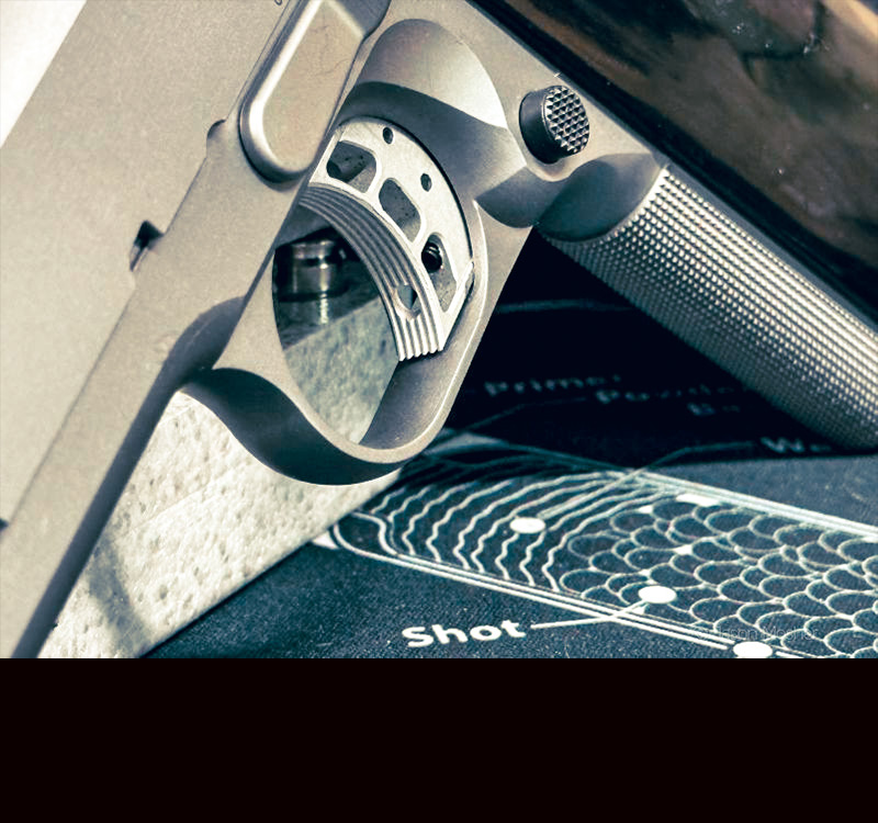 A close up view of a trigger on a 1911 pistol. 