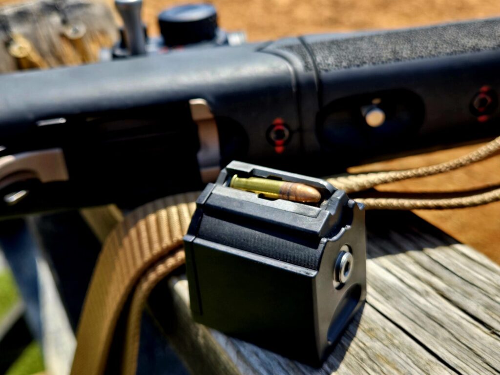 A rifle in the background with a Tactical Solutions R1 magazine in the foreground