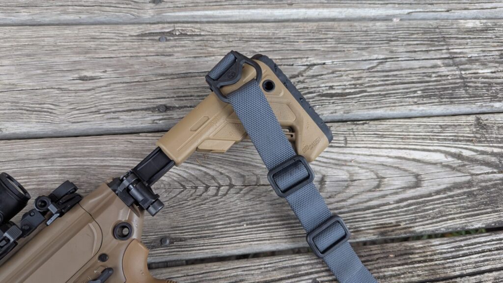 A close-up of the MS1 webbing and hardware near the folding stock hinge.