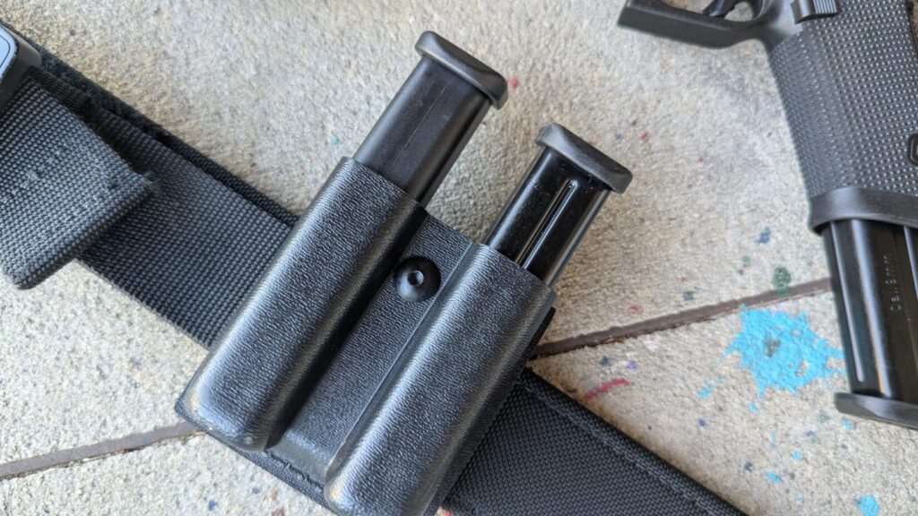 A double magazine pouch on a black duty belt holding two Mec-Gar Glock magazines.