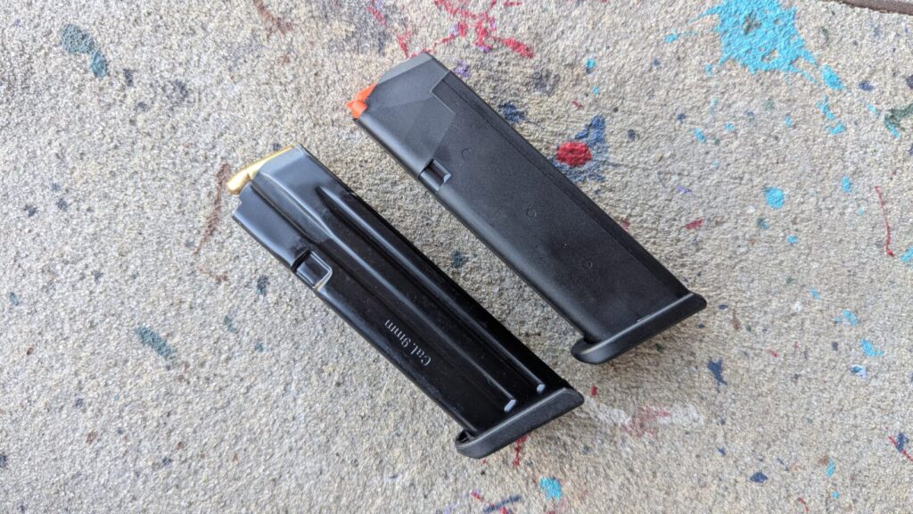 Side-by-side view of a steel Mec-Gar magazine and a factory Glock magazine resting on a textured surface.