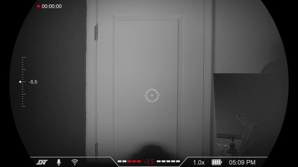 Clear grayscale night vision view of an indoor white door, demonstrating the device's performance in low-light interior settings.