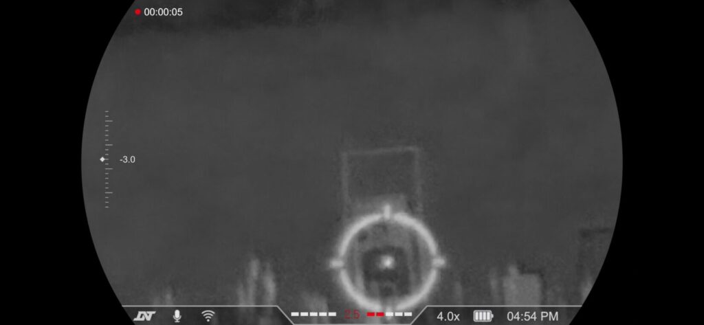 Night vision view focused on a target at 4.0x digital zoom, showing the increased pixelation and detail of the central reticle.