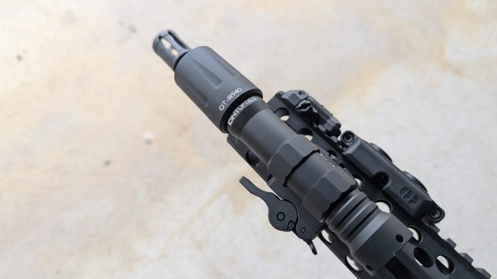 Close-up of an IR illuminator (QT-IR940) mounted to the side rail of an AR-15 handguard.