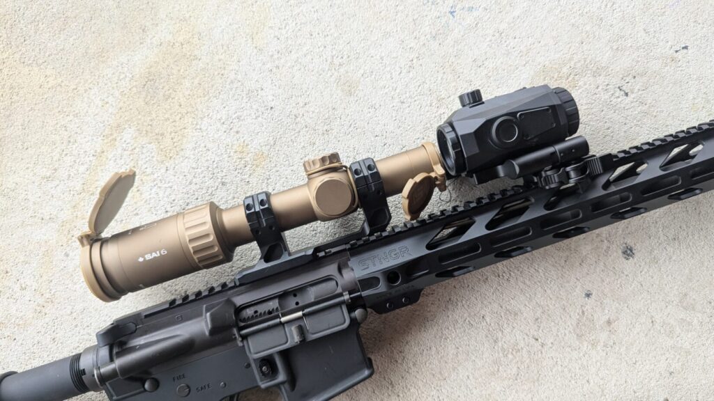 Profile view of a tan SAI 6 scope mounted on an AR-15, with the black NVMD-C200 unit attached in front of the objective lens.
