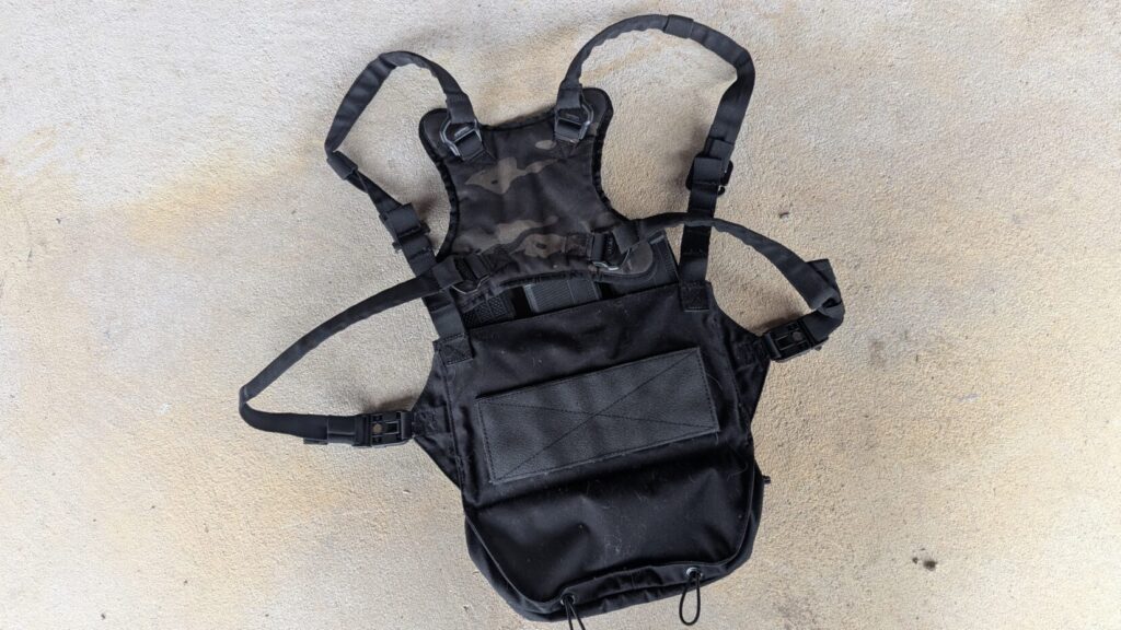 The back side of the Taculus rig showing a large hook-and-loop panel and the magnetic buckles on the straps.