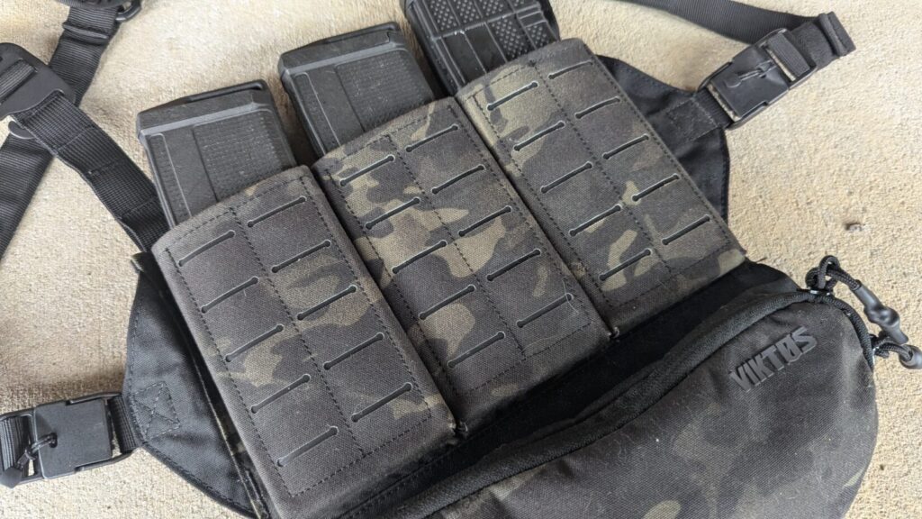 Three rifle magazines secured in laser-cut Multicam Black elastic cells on the front of the rig.