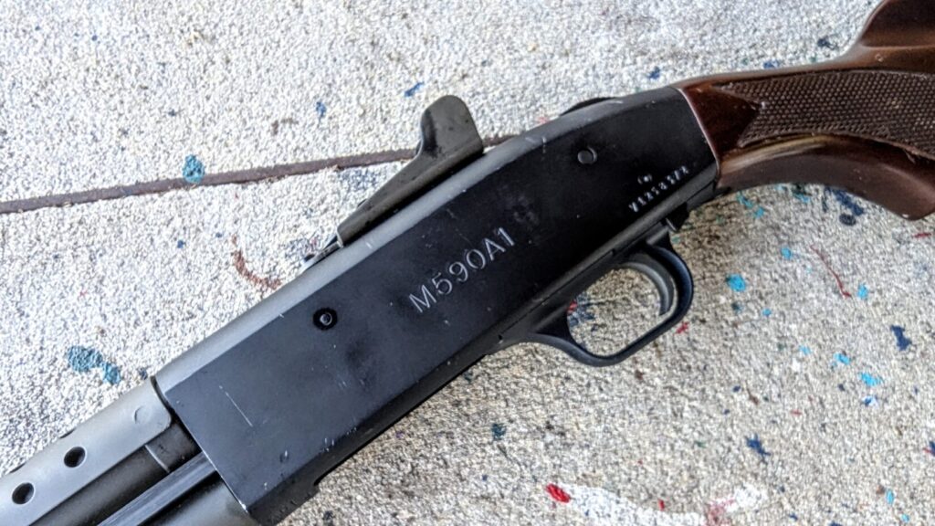 A detailed shot of the shotgun's receiver, showing the "M590A1" model engraving and the ghost ring rear sight.