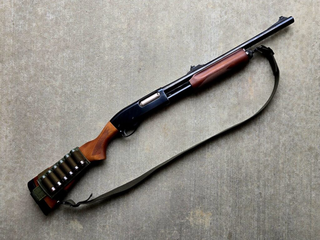 A remington 870 shotgun against a concrete backdrop