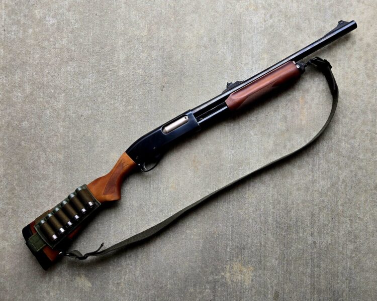 A remington 870 shotgun against a concrete backdrop