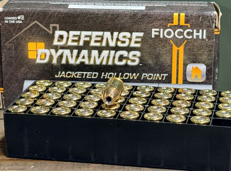 A box of ammo with the cartridges in front of it. 