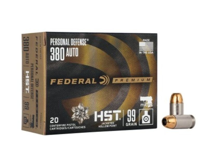 Two cartridges next to a black and gold box of Federal .380 HST ammo. 