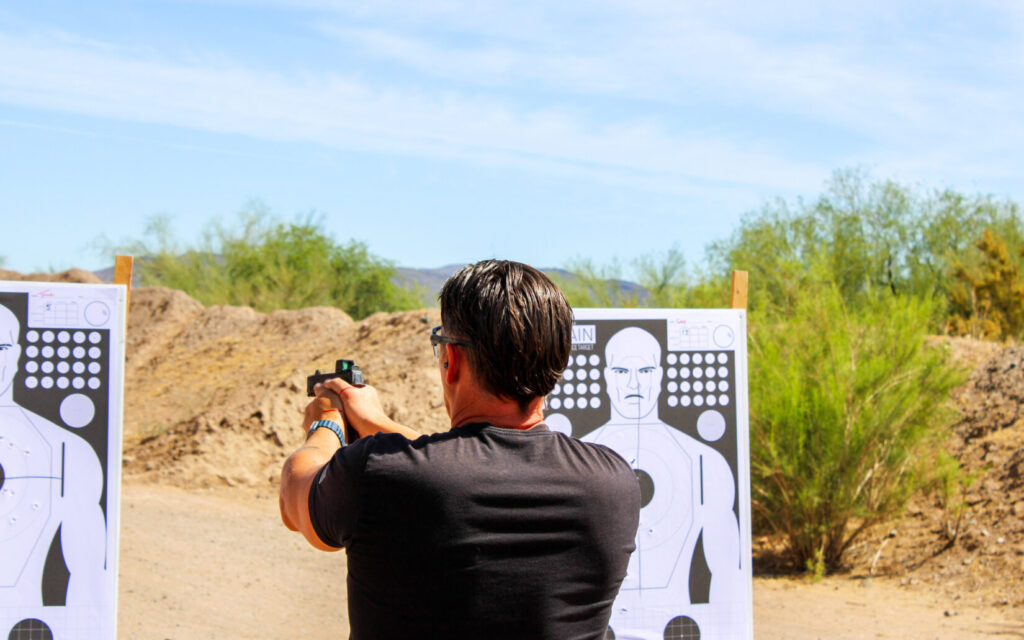 Man in a black shirt on a desert landscape.