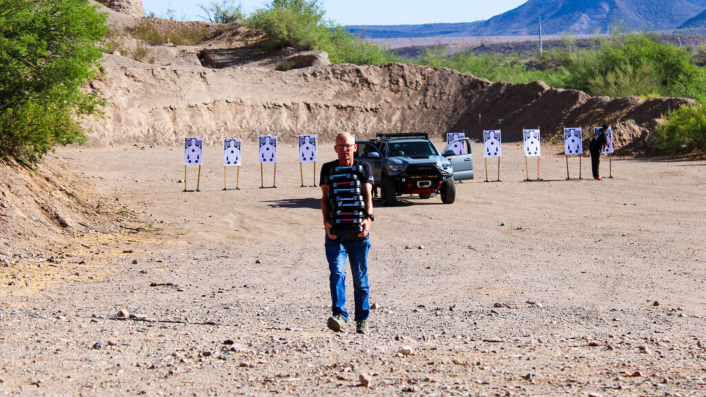 Man in a black shirt on a desert landscape.